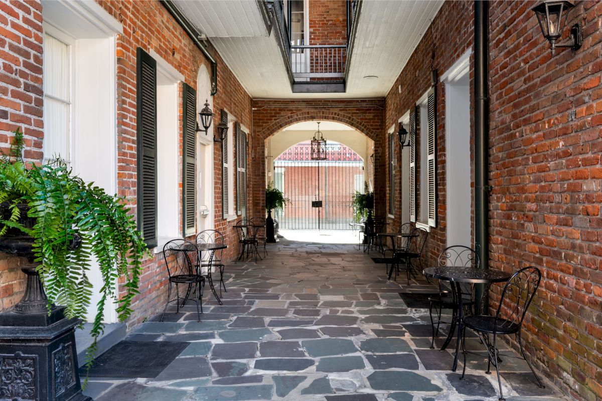 a covered outdoor seating area with brick walls and stone floors
