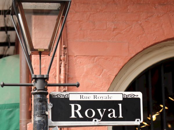 Street lamp and a "Royal" sign on a pink building, likely indicating Royal Street.